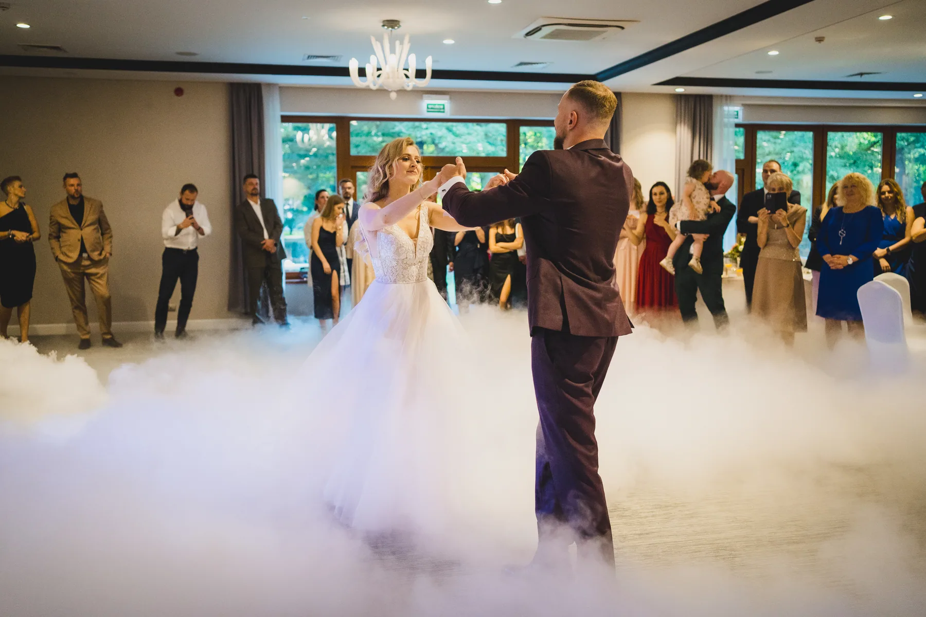 Pierwszy taniec pary młodej w sali w ciężkim dymie